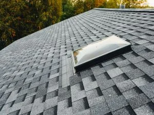 Gray asphalt shingle roof with installed ridge vent and proper shingle alignment